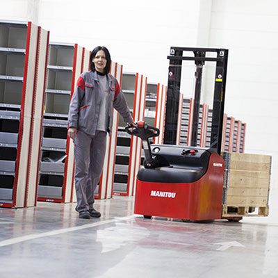 Picture showing a woman operating a Manitou warehouse truck
